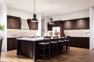 Spacious kitchen in the Legacy Barndominium featuring dark wood cabinetry, a large island with bar seating, and modern tile backsplash