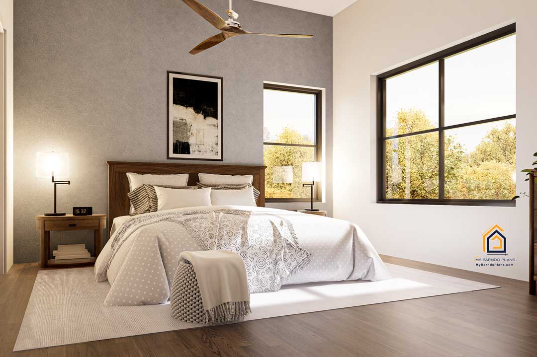 Bright master bedroom in the Shire Barndominium with a contemporary design, gray accent wall, stylish bedding, ceiling fan, and expansive windows offering serene outdoor views