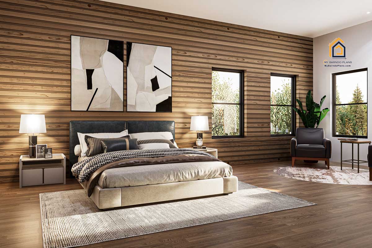 Spacious master bedroom in the Summit Barndominium featuring modern decor, cozy bedding, wood-paneled accent wall, and ample natural light from large windows