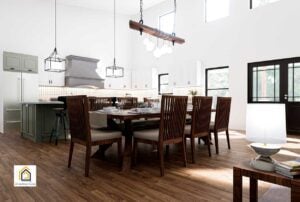Dining area inside The Arcadia barndominium with large windows, wooden table, and high ceilings.